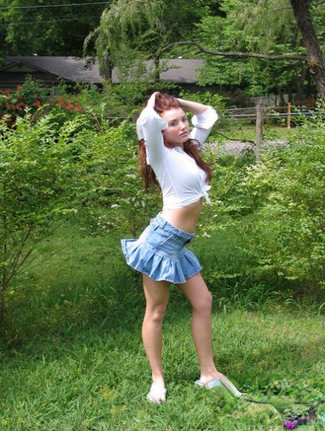 Young amateur model covers her boobs with her hands on the backyard lawn 67608803